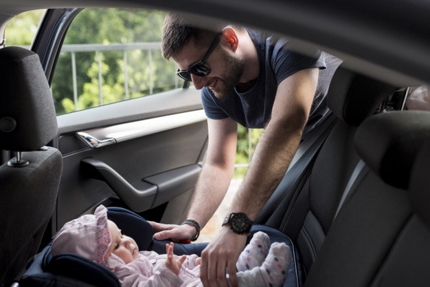 adult-man-taking-baby-out-infant-car-seat